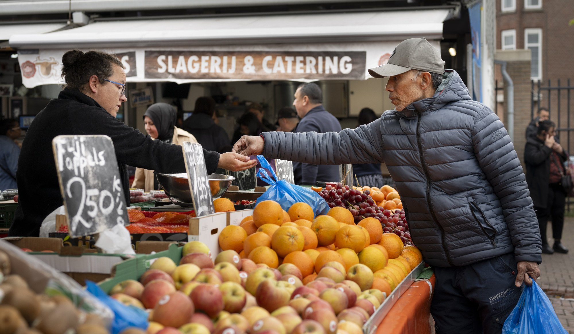 Man rekent af bij fruitkraam op de markt